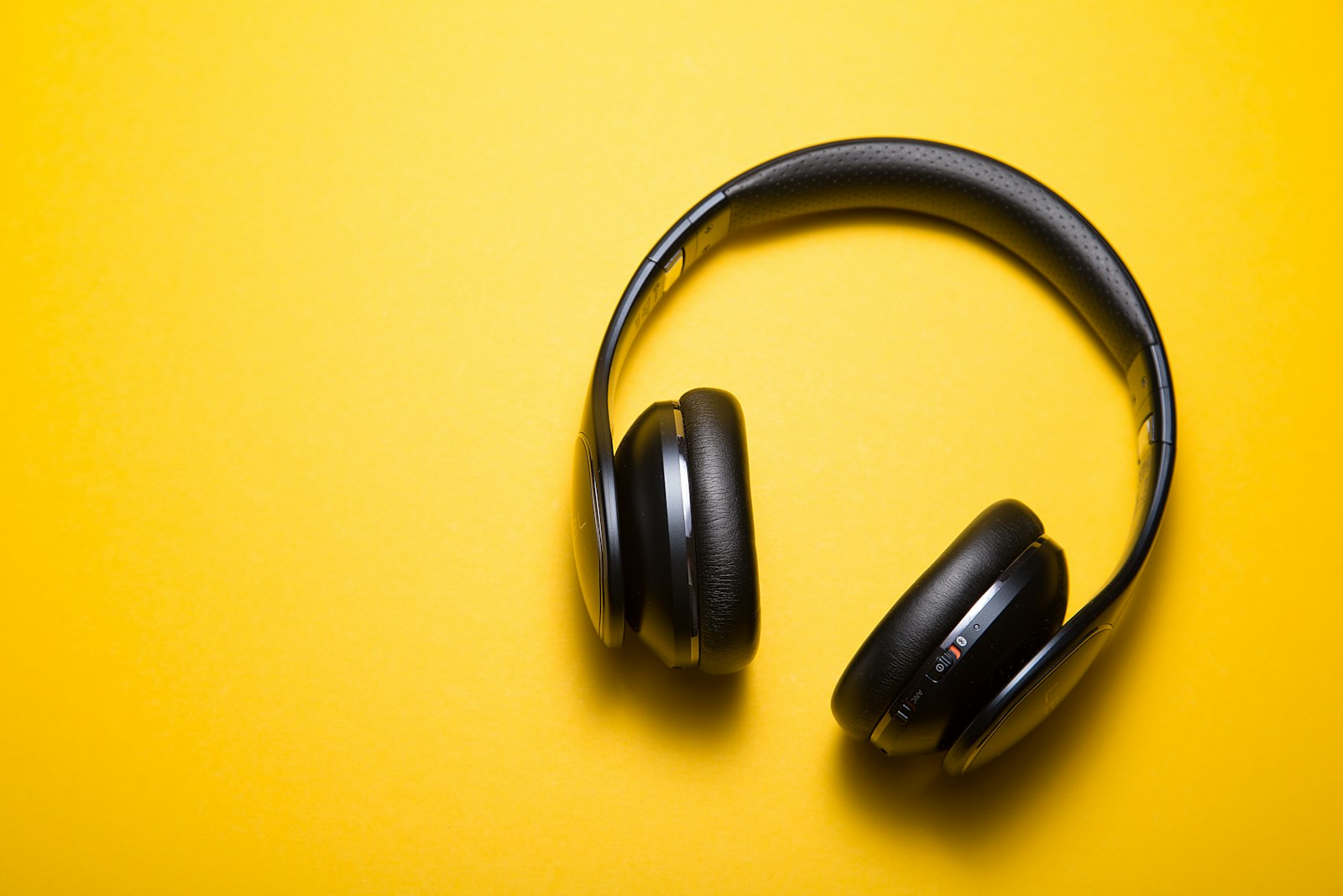Black headphones with leather-like pads on yellow